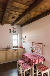 een keuken met een tafel met een rode en witte tafeldoek bij Zsindelyes Cottage in Érpatak