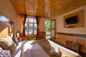 a bedroom with a bed and a tv on the wall at Rainbow Hostelier in Leh