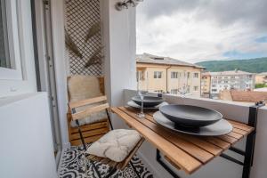 a balcony with a wooden table with two glasses on it at Cozy Little Place in Sighetu Marmaţiei