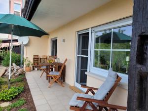 a patio with a table and chairs and an umbrella at Ferienwohnung Kraichgaublick in Angelbachtal