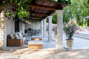 a covered patio with a table and chairs and flowers at La Bastide des Lavandins in Le Thor