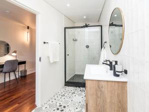 uma casa de banho com um lavatório e um chuveiro em Heriot Properties Units 19 & 20 em Joanesburgo