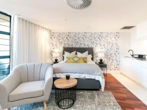 1 dormitorio con 1 cama, 1 silla y 1 mesa en Heriot Properties Units 19 & 20, en Johannesburgo