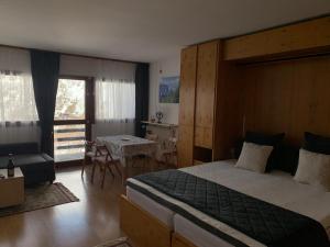 a bedroom with a large bed and a table and chairs at Cervinia Apartment 2112 in Breuil-Cervinia