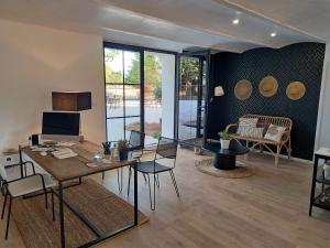 a living room with a table and chairs at Hôtel Le Cottage de Sophie in Valernes