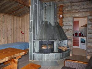 a living room with a fireplace in a log cabin at Karhujärven Kelopirtit in Karhujarvi +8 photos