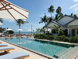 蘇梅島的住宿－Pearl of Samui Resort，度假村的游泳池,配有椅子和遮阳伞