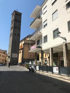 una torre del reloj alta sentada al lado de un edificio en La torre en Velletri