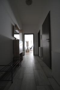 an empty room with a hallway with a door and a table at iHome Apartman 6.0 in Pécs
