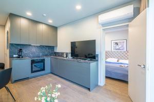 une cuisine avec des armoires bleues et un lit dans une chambre dans l'établissement Apartment w-Terrace I Air Condition I New building I Self Check-In, à Birštonas