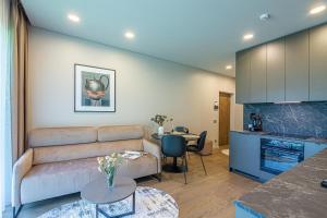 un salon avec un canapé et une table dans l'établissement Apartment w-Terrace I Air Condition I New building I Self Check-In, à Birštonas