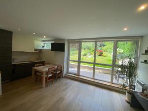 a kitchen with a table and a large window at Apartment Pusynas in Nida