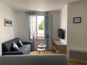 Una sala de estar con un sofá y un televisor. en Appartement familial, à Chessy, la ville de Disneyland Paris, en Chessy