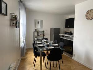 une salle à manger avec une table et des chaises ainsi qu'une cuisine dans l'établissement Appartement familial, à Chessy, la ville de Disneyland Paris, à Chessy