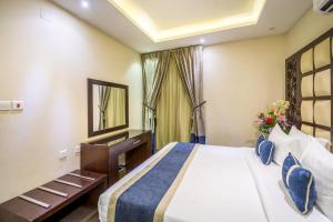 Habitación de hotel con cama y espejo en Al Muhaidib Hotel en Riad