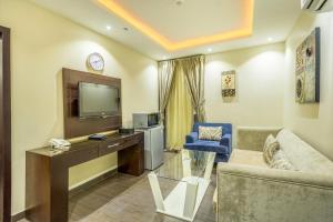 sala de estar con sofá y escritorio con TV en Al Muhaidib Hotel, en Riad