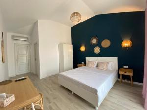 a bedroom with a large bed and a blue wall at Casa Ayan in 2 Mai