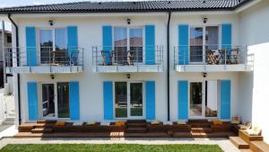 a blue and white house with a balcony at Casa Ayan in 2 Mai
