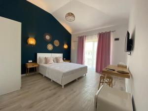 a bedroom with a bed and a blue wall at Casa Ayan in 2 Mai