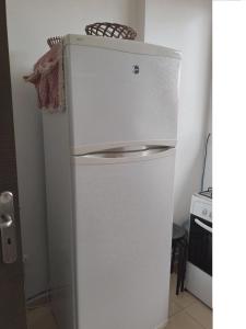 un frigorifero bianco con un cesto in cima di Joli Appartement Propre et Équipé: Jardins d'Ifran a Ifrane