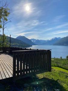 een houten terras met uitzicht op een meer bij Stryn - Faleide -hytte med fjord og fjell utsikt in Stryn