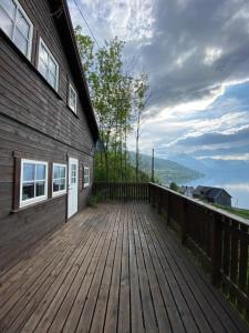una gran terraza de madera junto a un edificio en Stryn - Faleide -hytte med fjord og fjell utsikt, en Stryn