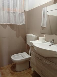 a bathroom with a white toilet and a sink at Capo Vaticano 7km Casa vacanze in Monte Poro in Coccorino