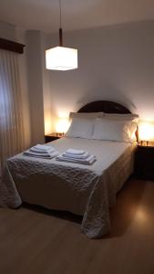 a bedroom with a bed with white sheets and pillows at Casa da Nanda in Crespos