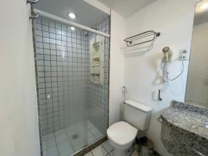 ein Bad mit einem WC und einer Glasdusche in der Unterkunft Thuis I Studio Espetacular na Praia do Canto in Vitória