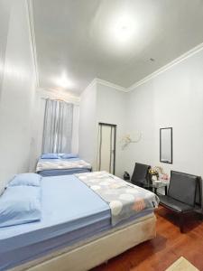 a bedroom with two beds and a table and chairs at Ministry Homestay in Yogyakarta