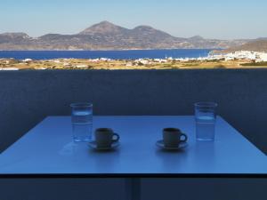 a table with two cups and a glass of water at Κallisto rooms in Mytakas