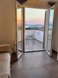 a room with a balcony with a table and a chair at Κallisto rooms in Mytakas