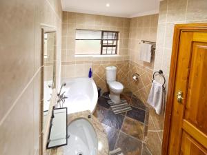 a bathroom with a tub and a toilet at Golf & Tides in Mossel Bay