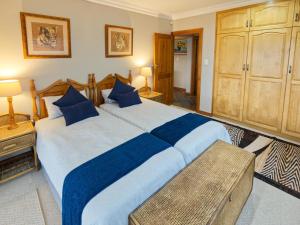 a large bedroom with a large bed with blue pillows at Golf & Tides in Mossel Bay