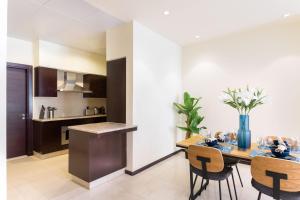 a kitchen and dining room with a table and chairs at Maison Privee - Luxury 1BR Apt Few Steps Away from the Beach in Dubai