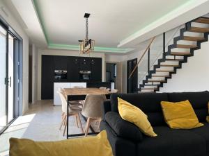 sala de estar con sofá negro y mesa en VILLA ELLA, en Puget-sur-Argens