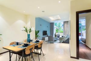 a dining room and living room with a table and chairs at Maison Privee - Luxury 1BR Apt Few Steps Away from the Beach in Dubai