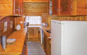 a kitchen with wooden cabinets and a white refrigerator at Nice Home In Dirdal With House Sea View in Dirdal