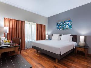 Rúm í herbergi á Kimaya Sudirman Yogyakarta by Harris