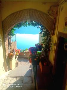 un arco in un edificio con dei fiori sopra di Giardino sul Lago con vasca Idromassaggio Jacuzzi a Castel Gandolfo