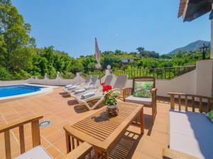 un patio con sillas, una mesa y una piscina en Cubo's La Casa del Rio, en Alhaurín el Grande