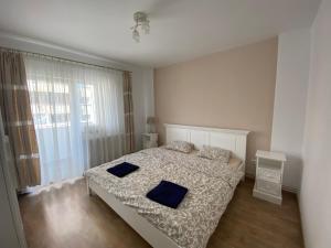 ein Schlafzimmer mit einem Bett mit blauen Kissen darauf in der Unterkunft Rose Peony in Cluj-Napoca