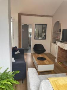 een woonkamer met een bank en een tafel bij Grand Appartement Hypercentre avec Terrasse et Parking in Poitiers