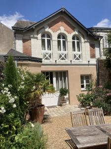 una casa con una mesa y sillas frente a ella en La Maison du Cocher - Studio climatisé en Hypercentre, en Angers