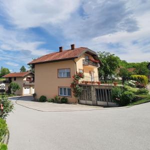 a large house with a balcony on a street at Kuca za odmor Juraj - Apartmani Barsic in Duga Resa