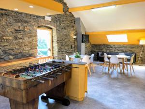 una sala de juegos con futbolín y pared de piedra. en Gîte de Groupe de la Semois, en Alle