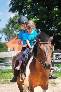 kobieta i dziecko jeżdżące na koniu w obiekcie Bałkanówka w mieście Kraśniczyn