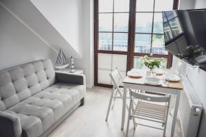 a living room with a couch and a table at Apartamenty Liliowa 3 in Dębki