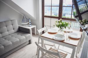 a living room with a table and a couch at Apartamenty Liliowa 3 in Dębki