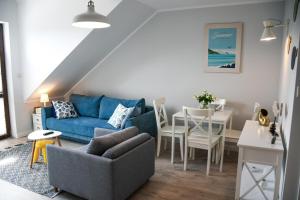 a living room with a blue couch and a table at Apartamenty Liliowa 3 in Dębki